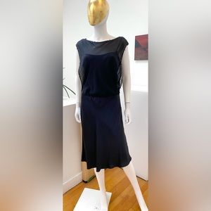 Black silk cocktail dress with a sheer bodice overlay.